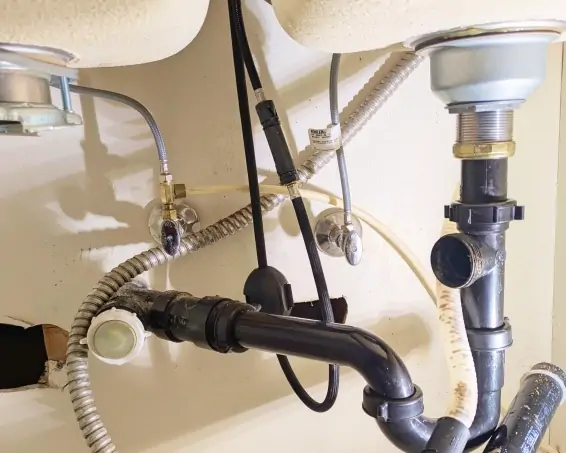 Supply and drain connections beneath a sink during a plumbing installation