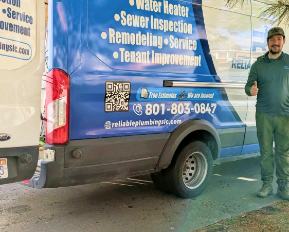 A Reliable Plumbing technician beside the company's branded service van